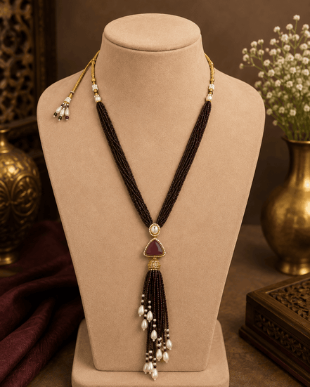 Dark purple cord tassel necklace with gold ring top and teardrop purple centerpiece