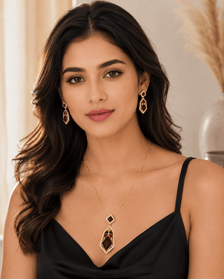 Gold-tone pendant necklace and drop earrings with dark red and blue stones, worn.
