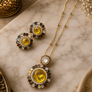Gold-tone necklace and round stud earrings with yellow center stones and blue accents